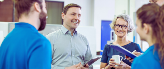 Glücklich wirkender Manager im Meeting mit seinen Angestellten