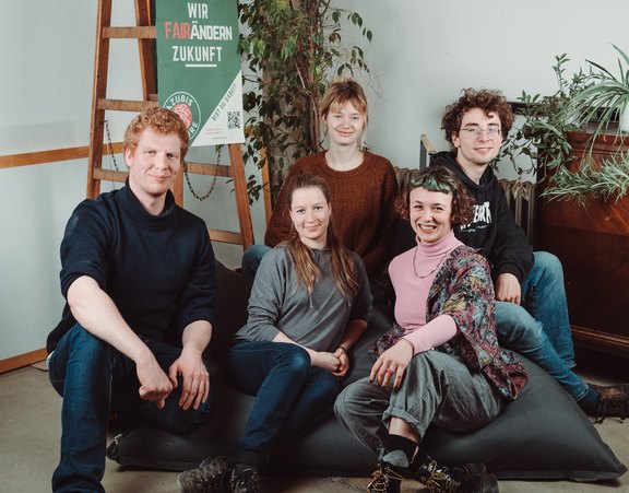 Zwei Männer und drei Frauen von Azubis4Future sitzen auf einem Sitzsack