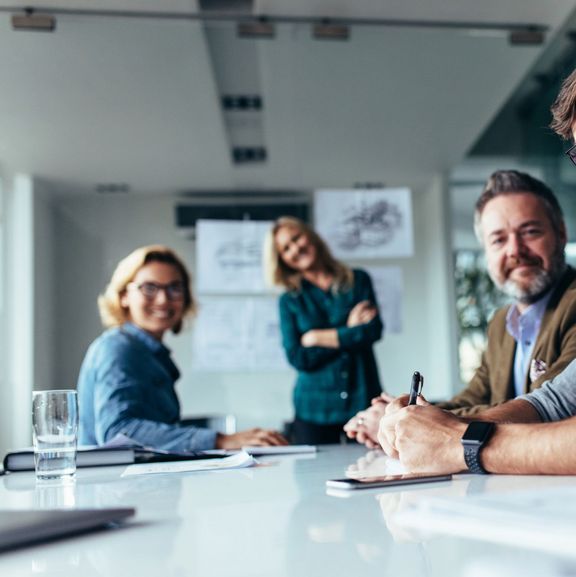 Vom Post zur Positionierung – Wie Unternehmenswerte Ihre Außenwirkung verstärken 2 Frauen und 2 Männer in einem Konferenzraum