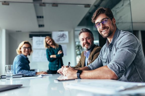 2 Frauen und 2 Männer in einem Konferenzraum