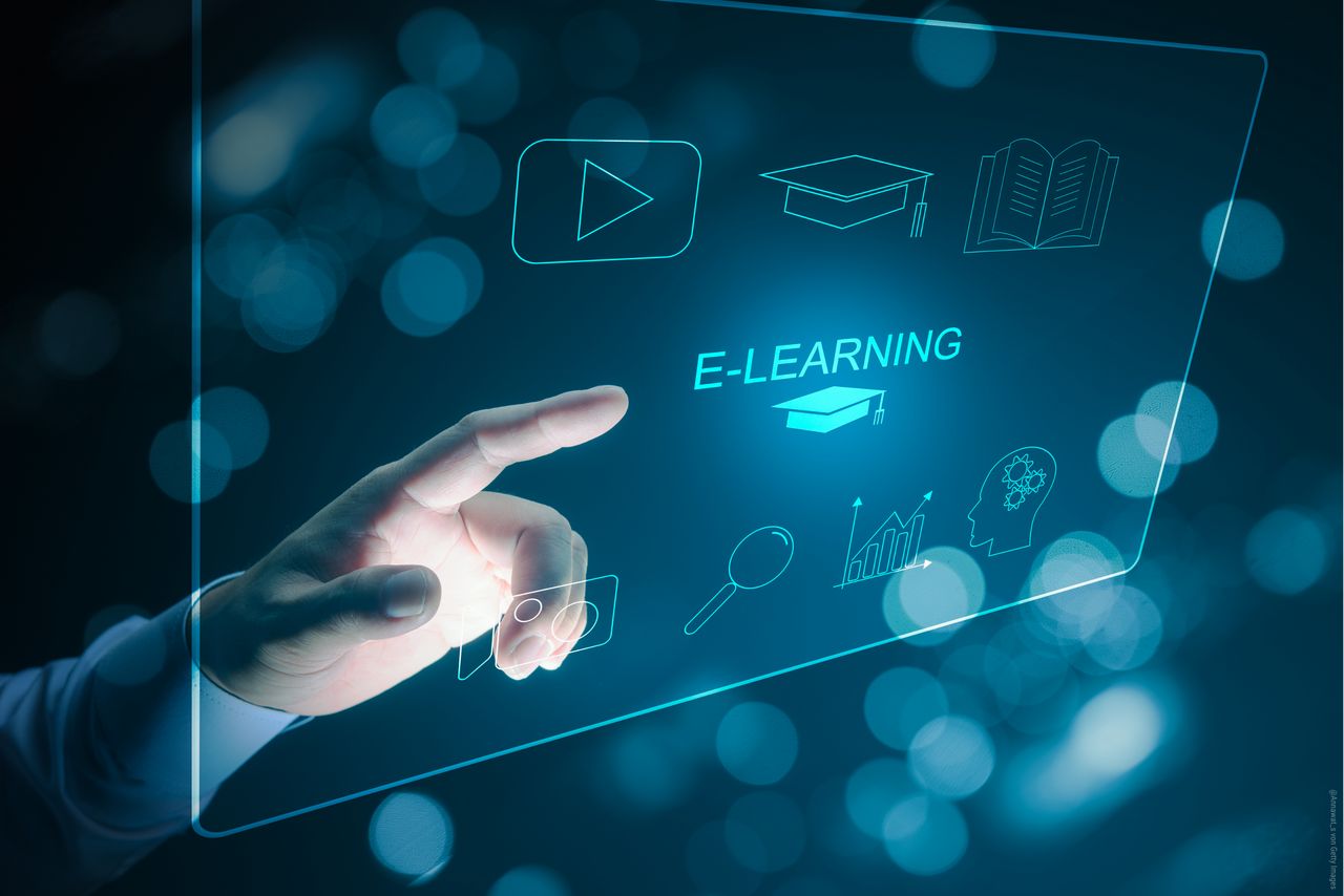 Ein Mann bedient ein Display und wählt E-Learning aus 