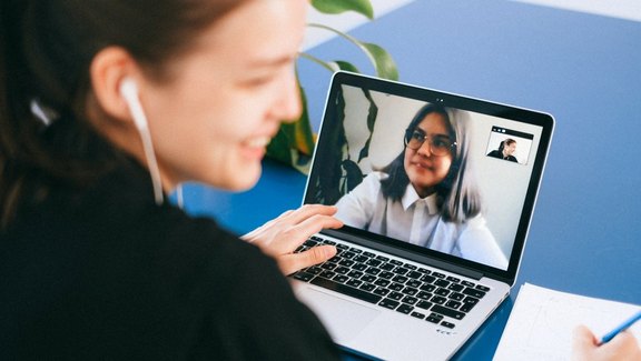 Zwei Frauen telefonieren online am Laptop