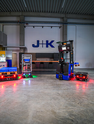Fünf Roboter stehen in einer Industriehalle. 