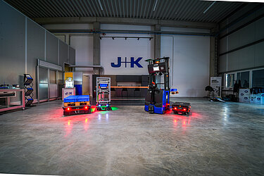 Fünf Roboter stehen in einer Industriehalle. 