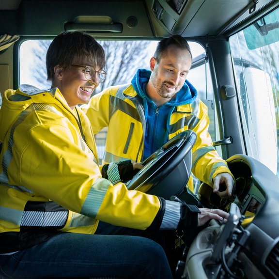 Zwei Personen im Lkw, lernen gemeinsam Fahrzeugtechnik kennen.