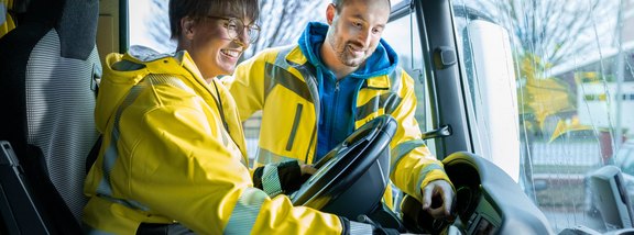 Zwei Personen im Lkw, lernen gemeinsam Fahrzeugtechnik kennen.