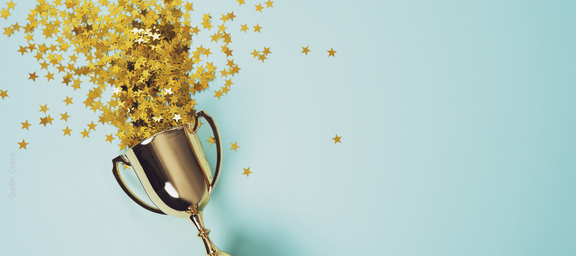 Pokal mit Sternchen auf blauem Hintergrund.