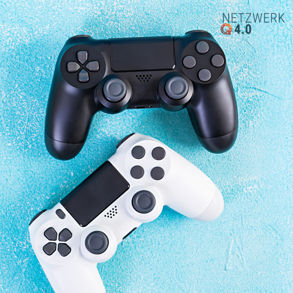 Schwarzer und weißer Gamecontroller auf türkisfarbenem Untergrund“