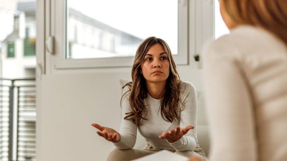 Eine junge traurige Frau auf dem Sofa
