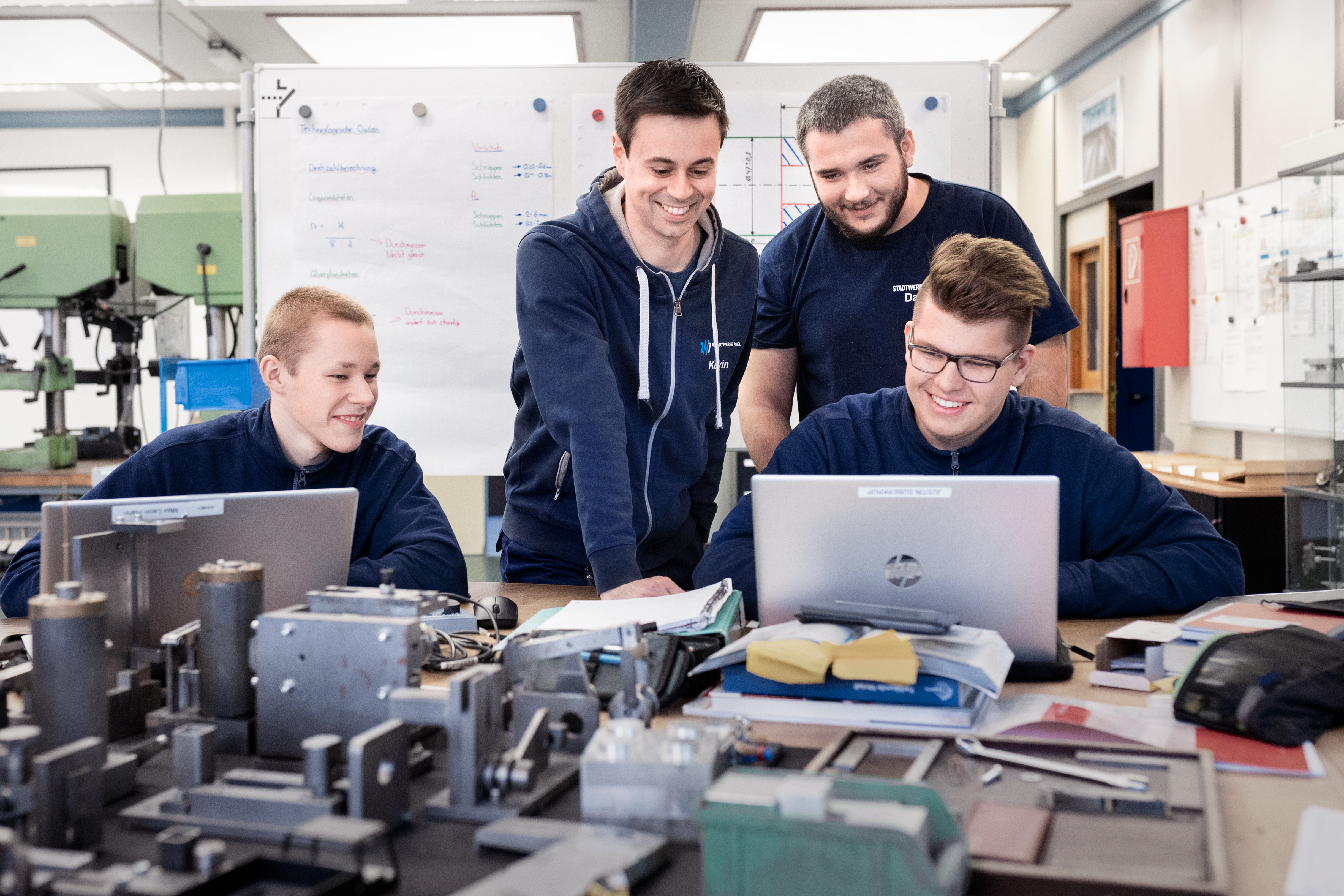 Lachende Azubis hinter einem Laptop